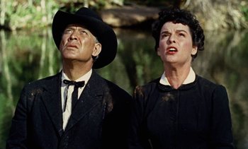 Movie still from “Johnny Guitar” (1954), directed by Nicholas Ray – An older man and a younger woman standing next to each other; Medium shot, Low angle