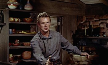 Movie still from “Johnny Guitar” (1954), directed by Nicholas Ray – A man holding a gun while standing in a room; Medium shot, Low angle
