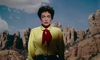 Movie still from “Johnny Guitar” (1954), directed by Nicholas Ray – A woman wearing a yellow shirt and red tie; Close Up shot, Low angle