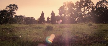 Movie still from “Jonah Hex” (2010), directed by Jimmy Hayward – A group of people riding horses on a grassy hill; Extreme Wide shot, Low angle