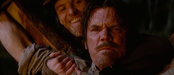 Movie still from “Jonah Hex” (2010), directed by Jimmy Hayward – Two men are looking at the camera while one holds a wooden stick; Close Up shot, Low angle