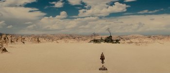 Movie still from “Jonah Hex” (2010), directed by Jimmy Hayward – A man is walking through the desert towards a factory; Extreme Wide shot, High angle