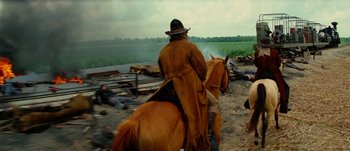 Movie still from “Jonah Hex” (2010), directed by Jimmy Hayward – A man riding on the back of a brown horse; Wide shot, Over the shoulder angle