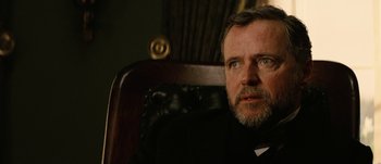 Movie still from “Jonah Hex” (2010), directed by Jimmy Hayward – A person sitting in a chair looking at the camera; Close Up shot, Low angle