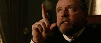 Movie still from “Jonah Hex” (2010), directed by Jimmy Hayward – A man with a beard and mustache is holding up a finger; Close Up shot, Low angle