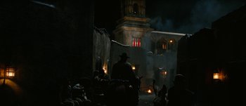 Movie still from “Jonah Hex” (2010), directed by Jimmy Hayward – A man sitting in front of a building at night; Extreme Wide shot, Low angle