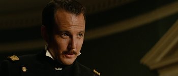 Movie still from “Jonah Hex” (2010), directed by Jimmy Hayward – A person wearing a suit and tie; Close Up shot, Low angle