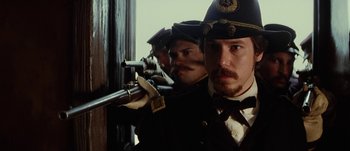 Movie still from “Jonah Hex” (2010), directed by Jimmy Hayward – A group of men standing next to each other holding guns; Close Up shot, Over the shoulder angle