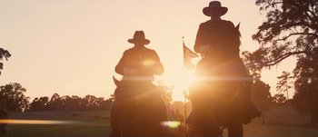 Movie still from “Jonah Hex” (2010), directed by Jimmy Hayward – Two men on horses in a field at sunset; Wide shot, Low angle