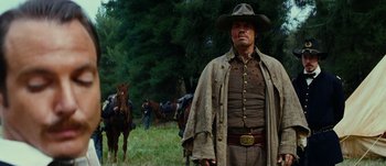 Movie still from “Jonah Hex” (2010), directed by Jimmy Hayward – A man in a cowboy hat standing next to a horse; Medium shot, Low angle