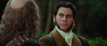 Movie still from “Jonah Hex” (2010), directed by Jimmy Hayward – A man with long hair and a beard looking at another man with long brown hair; Close Up shot, Low angle