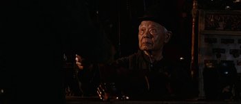 Movie still from “Jonah Hex” (2010), directed by Jimmy Hayward – An old man sitting at a table in a dimly - lit room; Close Up shot, Over the shoulder angle