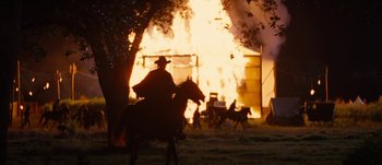 Movie still from “Jonah Hex” (2010), directed by Jimmy Hayward – A man riding a horse in front of a burning building; Wide shot, Low angle