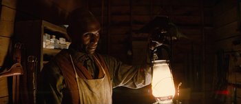 Movie still from “Jonah Hex” (2010), directed by Jimmy Hayward – A man in an apron is holding a lantern; Close Up shot, Low angle