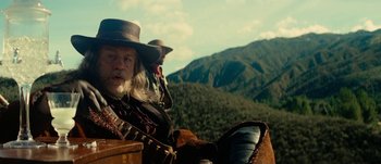 Movie still from “Jonah Hex” (2010), directed by Jimmy Hayward – A man in a cowboy hat sitting on a horse in front of a mountain range; Medium shot, Low angle