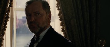 Movie still from “Jonah Hex” (2010), directed by Jimmy Hayward – A person wearing a suit and tie; Close Up shot, Over the shoulder angle