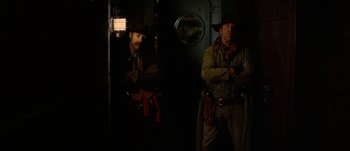 Movie still from “Jonah Hex” (2010), directed by Jimmy Hayward – Two men are standing in a dark room; Medium shot, Low angle