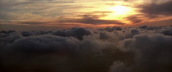 Movie still from “Jonathan Livingston Seagull” (1973), directed by Hall Bartlett – The sun is setting over the clouds in the sky; Extreme Wide shot, High angle