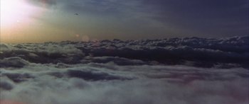 Movie still from “Jonathan Livingston Seagull” (1973), directed by Hall Bartlett – A bird flying above a cloud filled sky; Extreme Wide shot, Low angle