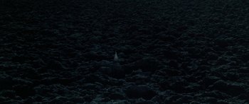 Movie still from “Jonathan Livingston Seagull” (1973), directed by Hall Bartlett – A bird is standing in the middle of a field; Extreme Wide shot, Overhead angle