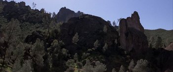 Movie still from “Jonathan Livingston Seagull” (1973), directed by Hall Bartlett – A mountain with a bunch of trees on top of it; Extreme Wide shot, Low angle