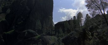 Movie still from “Jonathan Livingston Seagull” (1973), directed by Hall Bartlett – A view of a mountain with trees in the background; Extreme Wide shot, High angle