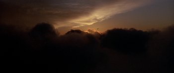 Movie still from “Jonathan Livingston Seagull” (1973), directed by Hall Bartlett – A bird flying in the middle of a dark sky at sunset; Extreme Wide shot, Low angle