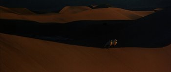 Movie still from “Jonathan Livingston Seagull” (1973), directed by Hall Bartlett – Three birds are standing on the sand dunes at night; Extreme Wide shot, High angle