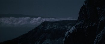 Movie still from “Jonathan Livingston Seagull” (1973), directed by Hall Bartlett – A mountain range with a cloudy sky in the background; Extreme Wide shot, Low angle