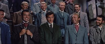 Movie still from “Journey to the Center of the Earth” (1959), directed by Henry Levin – A group of men standing next to each other in suits and ties; Medium shot, Low angle