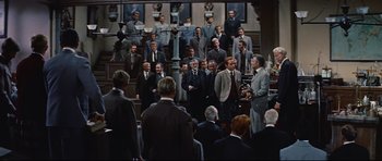 Movie still from “Journey to the Center of the Earth” (1959), directed by Henry Levin – A group of men in suits standing in front of a crowd; Wide shot, High angle