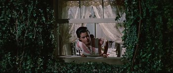 Movie still from “Journey to the Center of the Earth” (1959), directed by Henry Levin – A woman leaning on a window sill looking out a window; Medium shot, Low angle