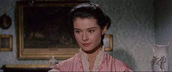 Movie still from “Journey to the Center of the Earth” (1959), directed by Henry Levin – A woman in a pink shirt with a white ruffle around her neck; Close Up shot, Over the shoulder angle