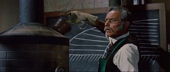 Movie still from “Journey to the Center of the Earth” (1959), directed by Henry Levin – An older man holding a wine glass in his hand; Medium shot, Low angle