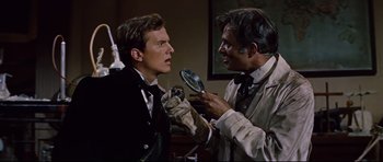 Movie still from “Journey to the Center of the Earth” (1959), directed by Henry Levin – A man holding a magnifying glass over another man's face; Close Up shot, Over the shoulder angle