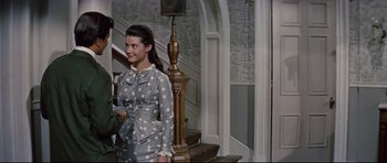 Movie still from “Journey to the Center of the Earth” (1959), directed by Henry Levin – A woman in a polka dot dress standing in front of a staircase; Medium shot, Low angle