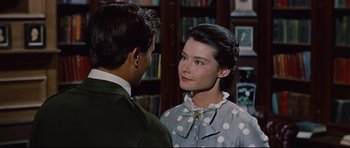 Movie still from “Journey to the Center of the Earth” (1959), directed by Henry Levin – A man and a woman standing next to each other in a library; Close Up shot, Over the shoulder angle