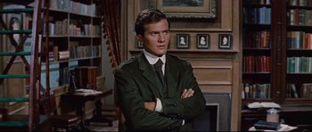 Movie still from “Journey to the Center of the Earth” (1959), directed by Henry Levin – A man in a suit and tie with his arms crossed; Medium shot, Low angle