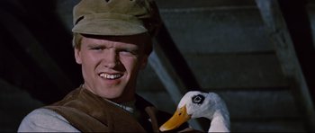 Movie still from “Journey to the Center of the Earth” (1959), directed by Henry Levin – A man holding a duck in his hand and smiling for the camera; Close Up shot, Low angle