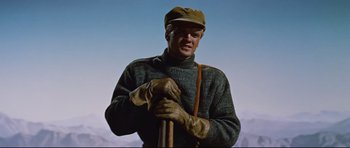 Movie still from “Journey to the Center of the Earth” (1959), directed by Henry Levin – A man in a sweater and hat holding a stick; Medium shot, Low angle