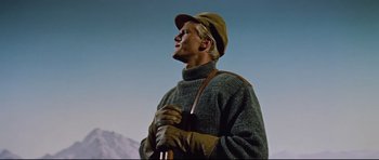 Movie still from “Journey to the Center of the Earth” (1959), directed by Henry Levin – A man in a sweater and hat holding a rifle; Medium shot, Low angle