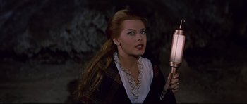 Movie still from “Journey to the Center of the Earth” (1959), directed by Henry Levin – A woman with long hair holding a mirror in a dark room; Close Up shot, High angle