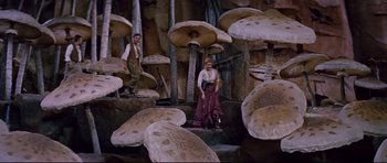 Movie still from “Journey to the Center of the Earth” (1959), directed by Henry Levin – A man and a woman standing next to a bunch of mushrooms; Wide shot, High angle