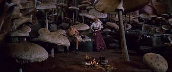 Movie still from “Journey to the Center of the Earth” (1959), directed by Henry Levin – A man and a woman sitting in front of a pile of mushrooms; Wide shot, High angle