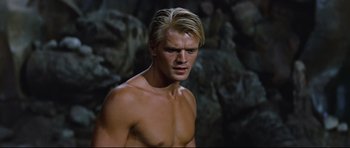 Movie still from “Journey to the Center of the Earth” (1959), directed by Henry Levin – A man with blonde hair and a bare chest; Close Up shot, Low angle