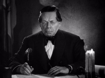 Movie still from “Juarez” (1939), directed by William Dieterle – An old photo of a man writing on a paper; Close Up shot, High angle
