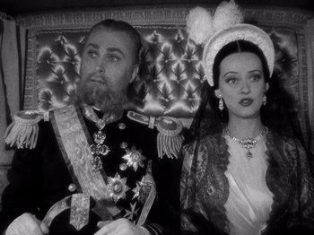 Movie still from “Juarez” (1939), directed by William Dieterle – A man and a woman dressed up as a royal couple; Medium shot, High angle