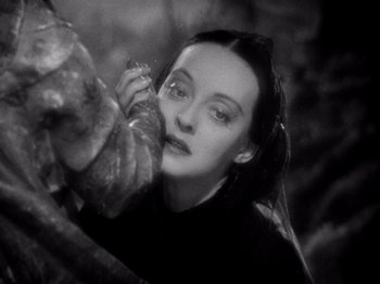 Movie still from “Juarez” (1939), directed by William Dieterle – A black - and - white photo of a woman eating a pastry; Close Up shot, Low angle