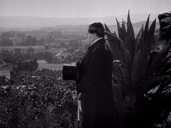 Movie still from “Juarez” (1939), directed by William Dieterle – An older man standing on top of a hill looking out over a valley; Medium shot, High angle