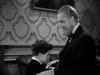 Movie still from “Juarez” (1939), directed by William Dieterle – An older man and a young boy in a room; Medium shot, High angle